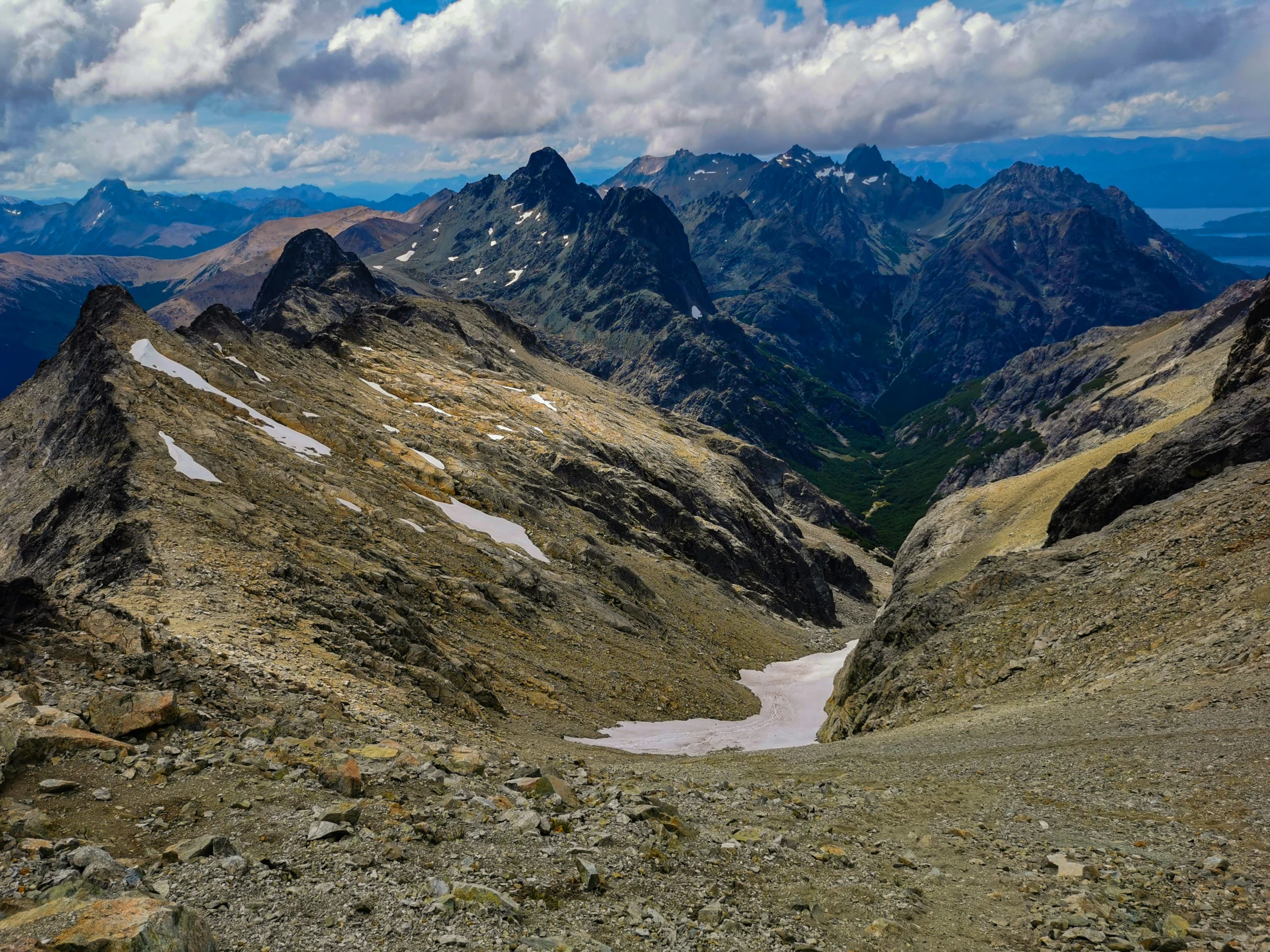 two large mountains under a cloudy blue sky