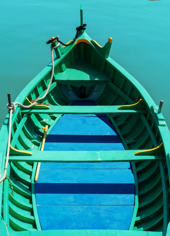 blue boat in the water with a yellow pole