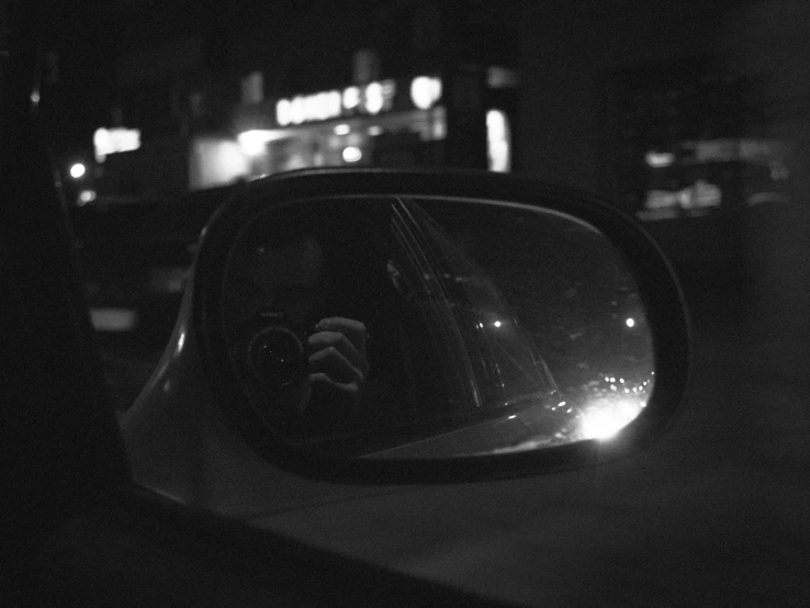 a car is seen in the side mirror of its headlight