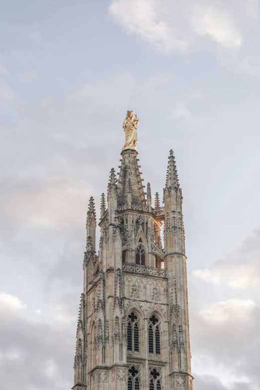 the tower of a cathedral has sculptures on it