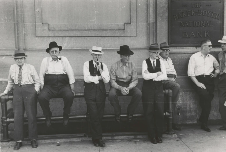 six people sitting on a bench wearing hats