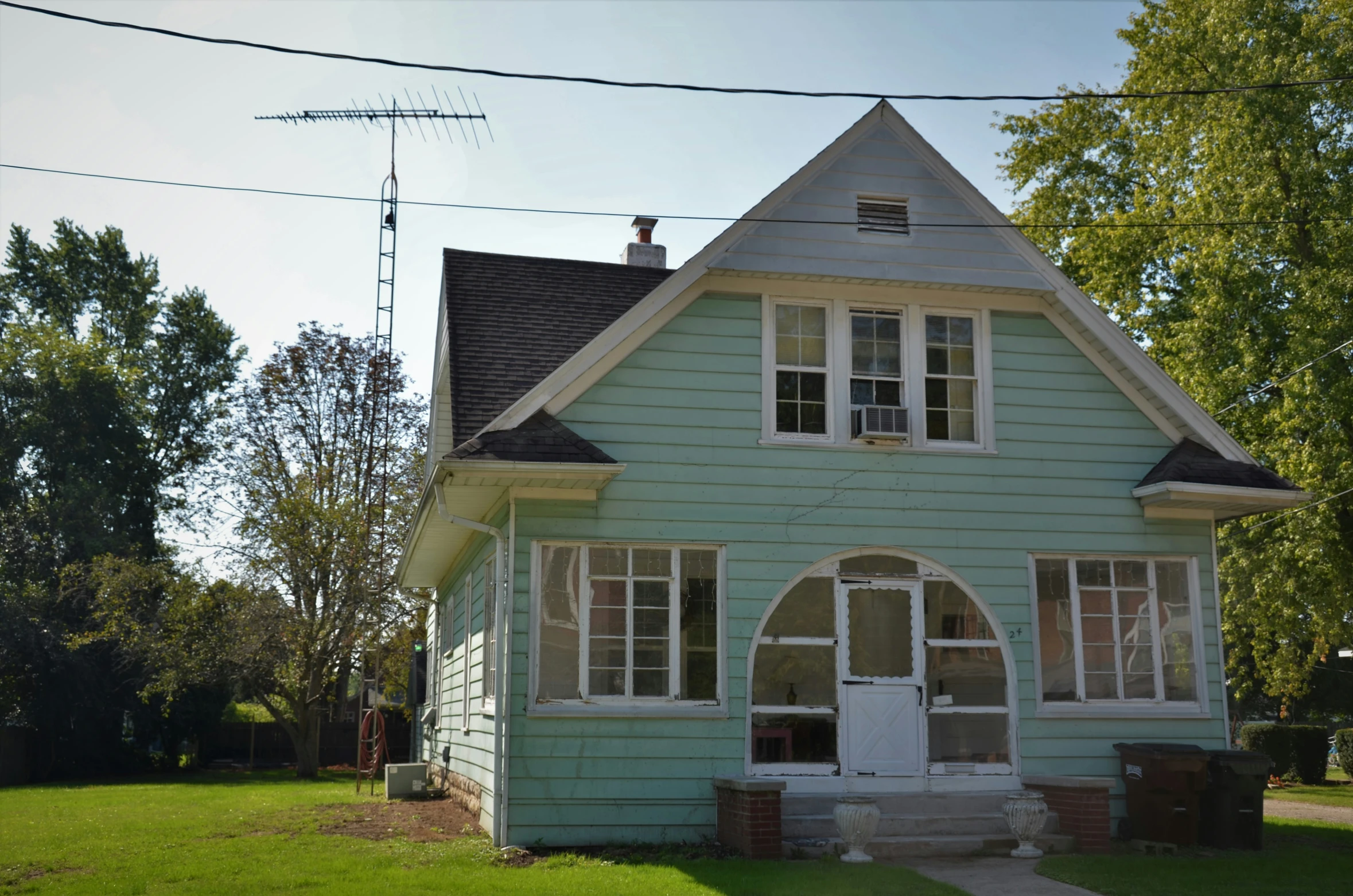 a blue house sitting in the middle of a yard