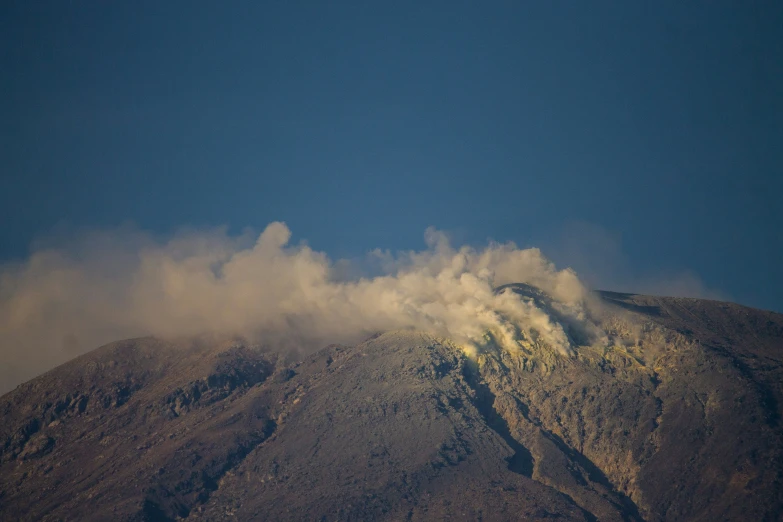 a mountain with a few very pretty clouds on top