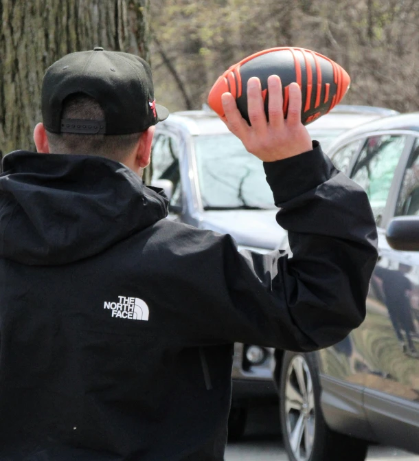 a man holding an orange ball in his hands