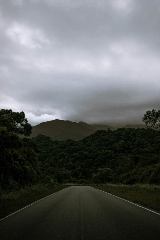 an asphalt road with mountains in the distance