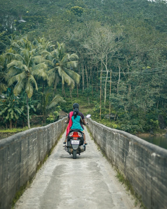 a person riding on a motorcycle with a backpack and a red coat