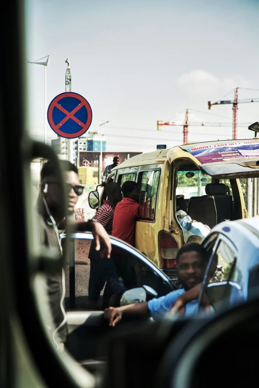 a yellow van on the street with people standing around it