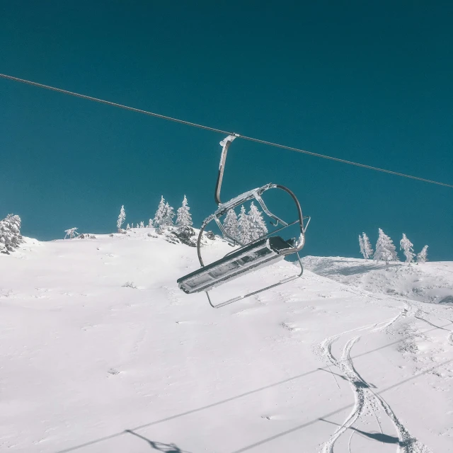 a ski lift on the side of a mountain covered in snow