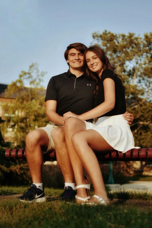 a couple sitting together on a bench posing for the camera