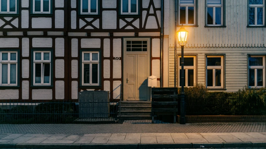 a small old fashion building at night with its lantern light on