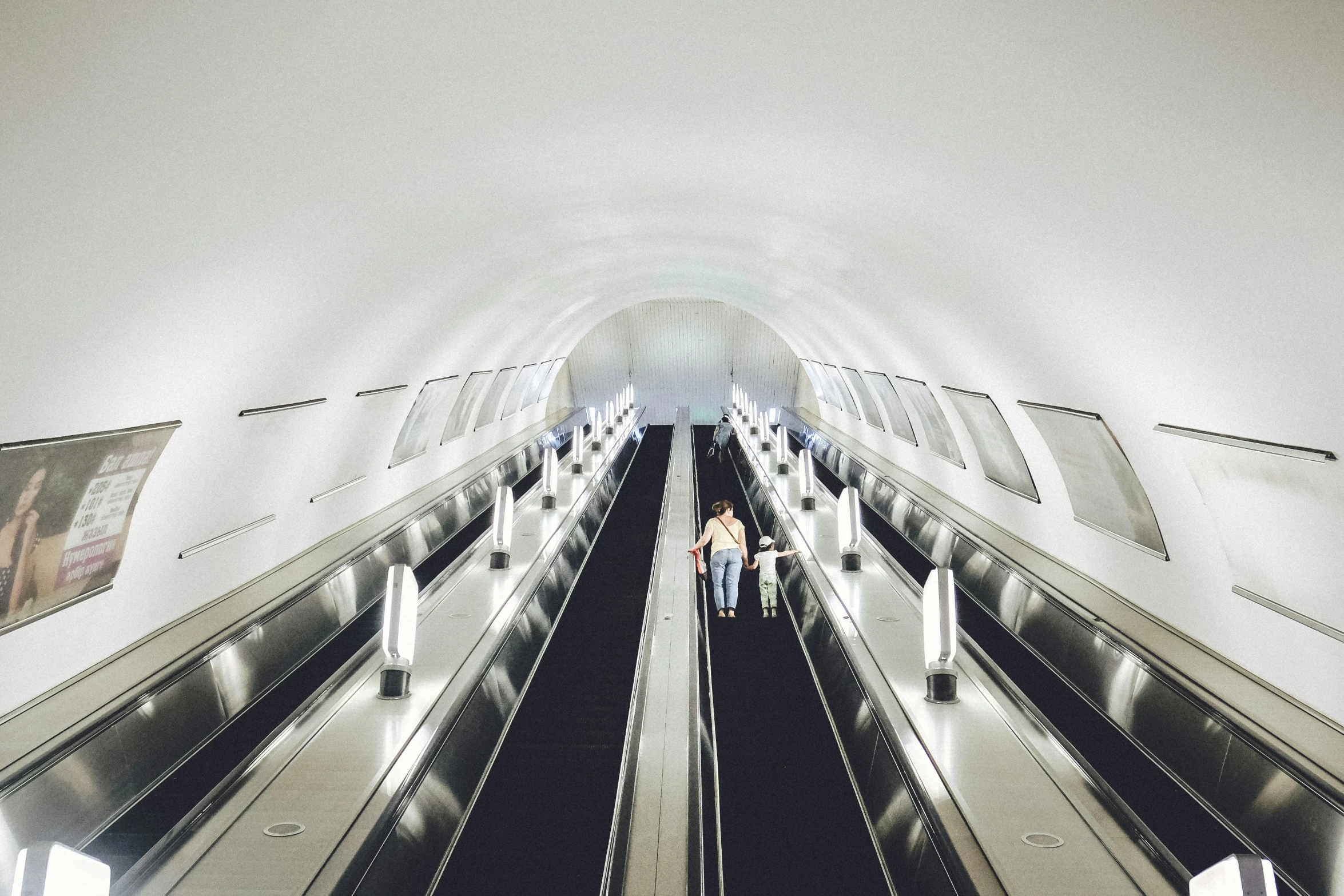 people in a big airport with escalator and windows