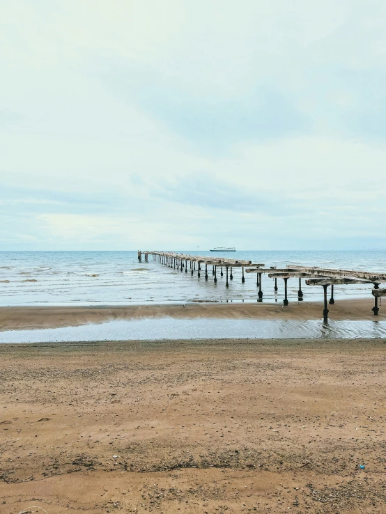 a small boat dock near the beach is next to the ocean