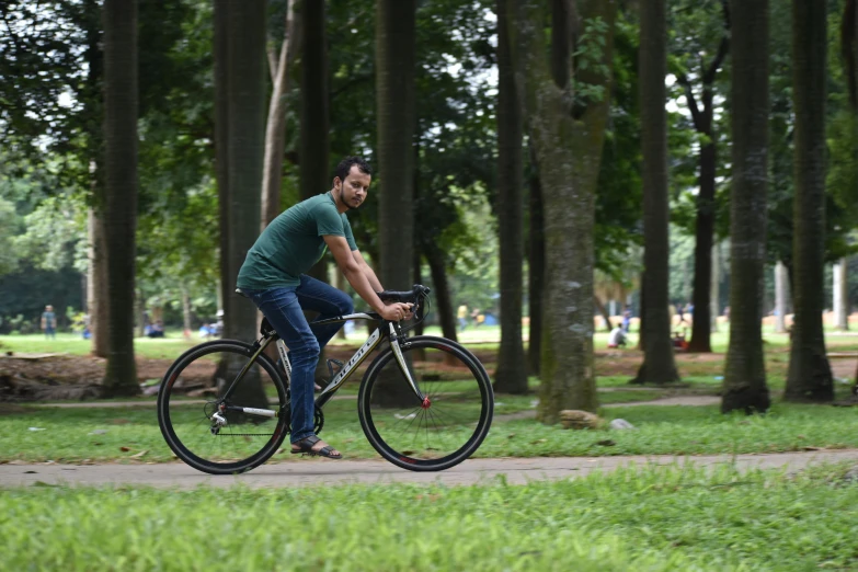 a man on a bicycle riding in the park