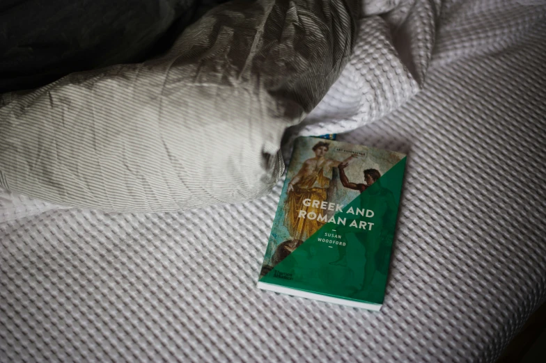 the book called green man, by yohana maha is laying on a bed