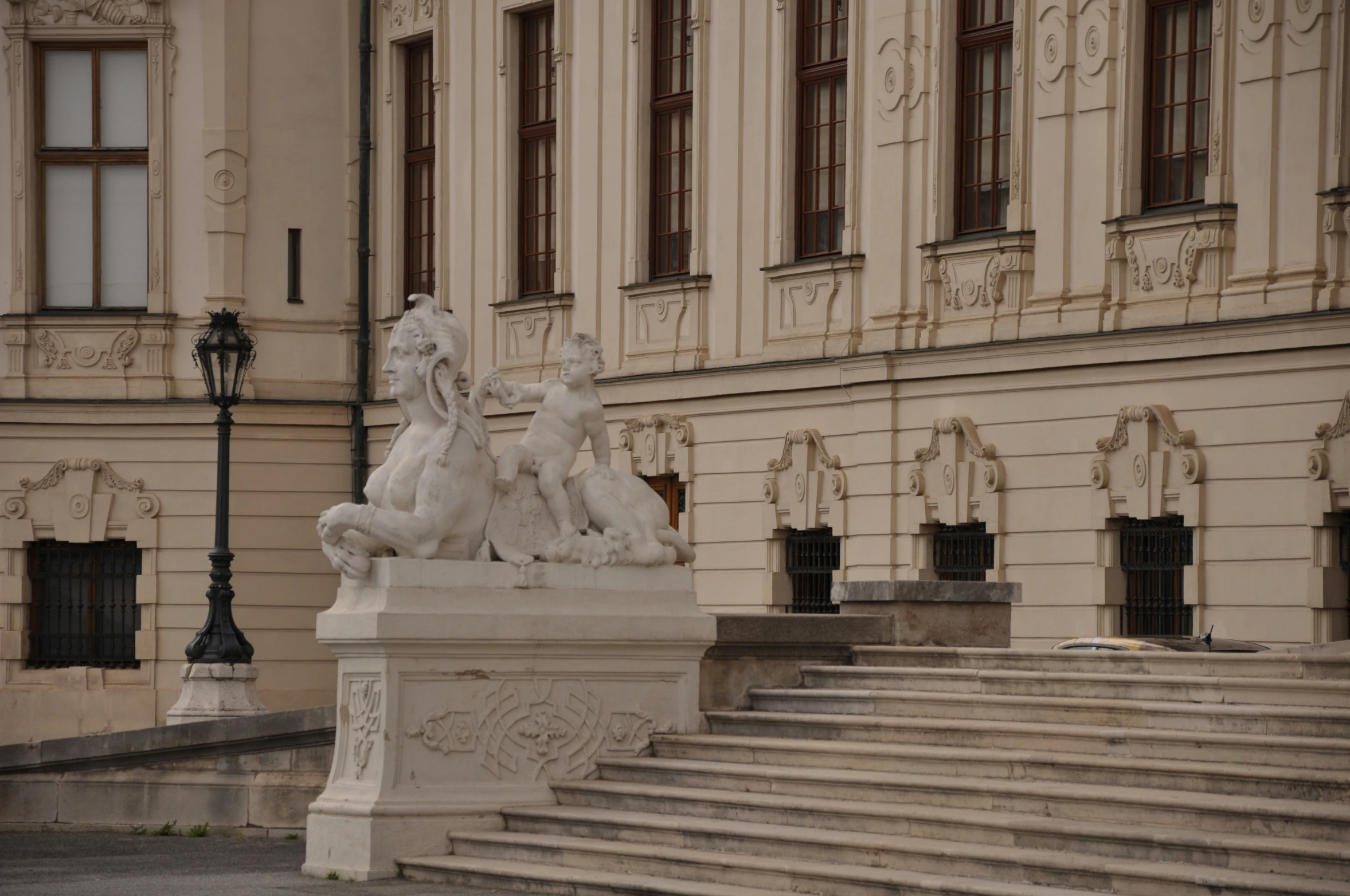 four sculptures sit on top of the marble steps