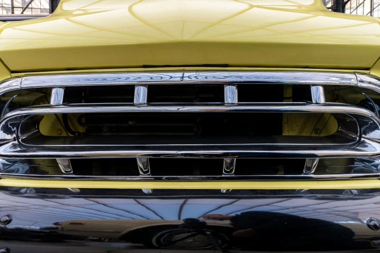 the front end of a yellow truck that is painted in silver