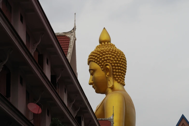 a golden buddha statue sitting in front of a building