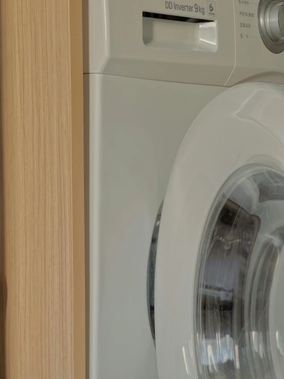 a white washing machine with wood door handles