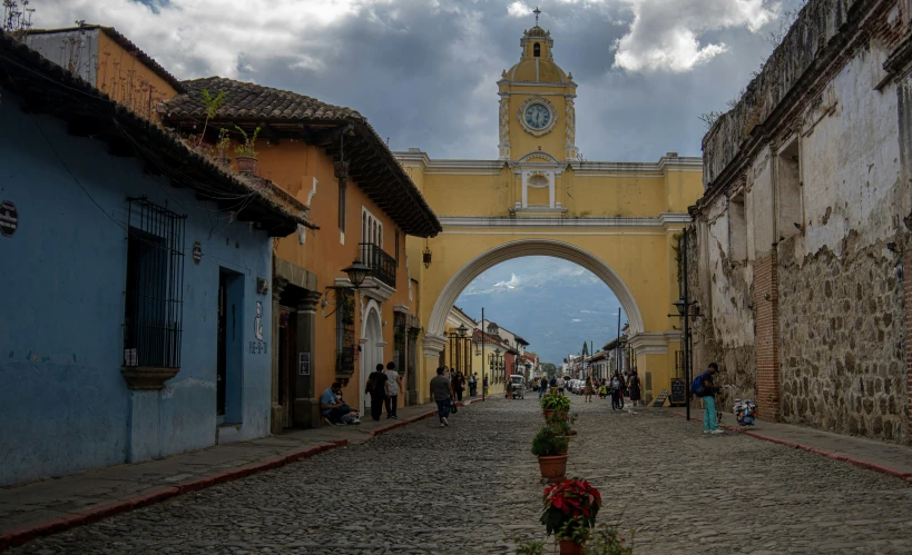 a cobblestone road has a clock tower on it