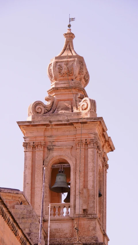 a bell tower with a bell and flag on the outside