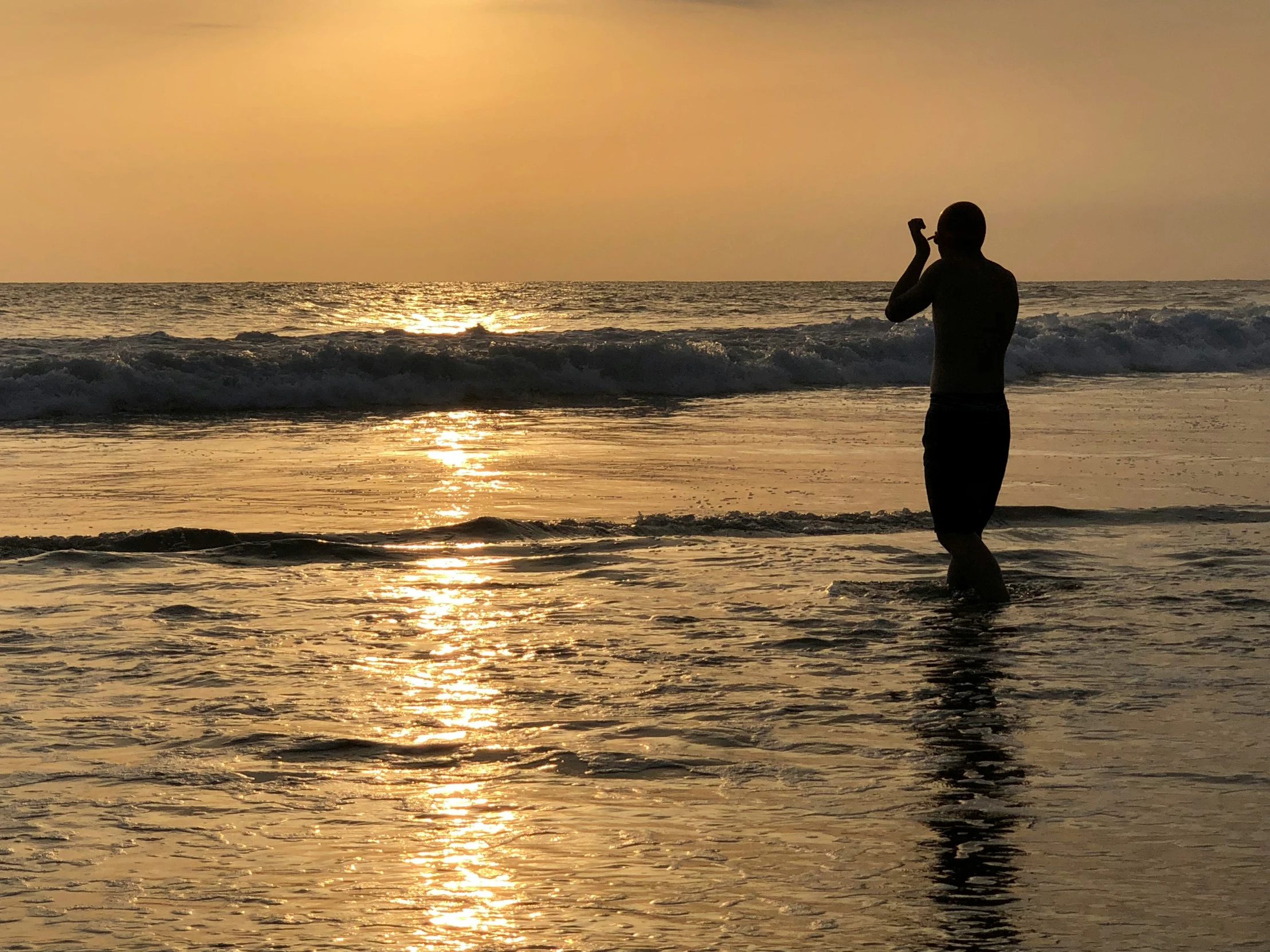 a man standing in the water while holding a frisbee