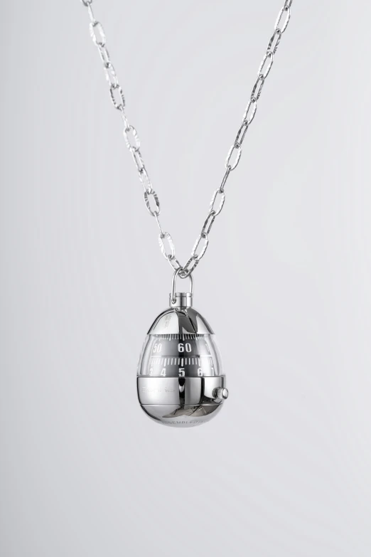 a silver bell necklace on a chain