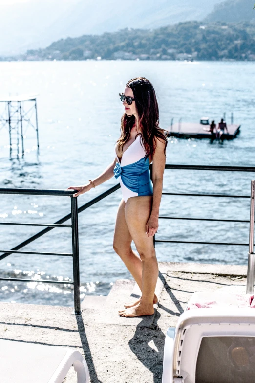 a beautiful woman in blue and white swimsuit on the deck