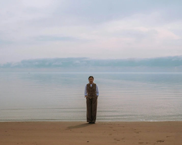 a person standing on the beach near water