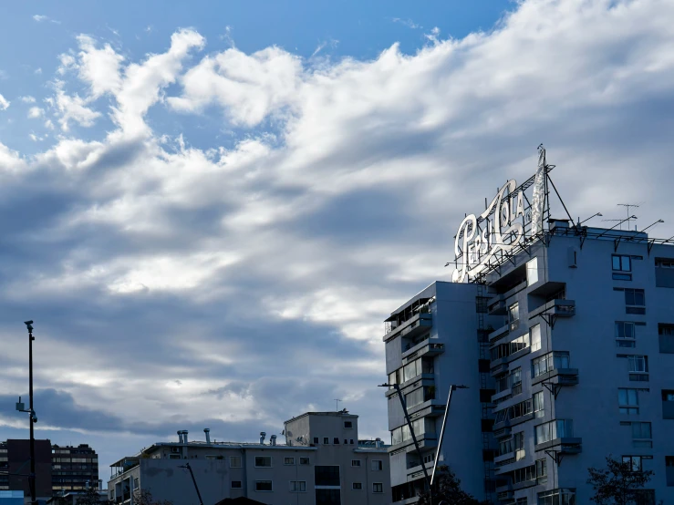 the sky is covered with clouds and some buildings