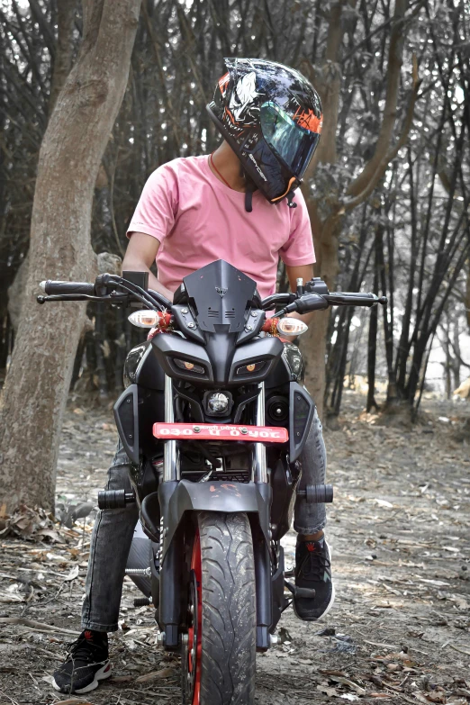 man riding motorcycle on trail near trees on cloudy day