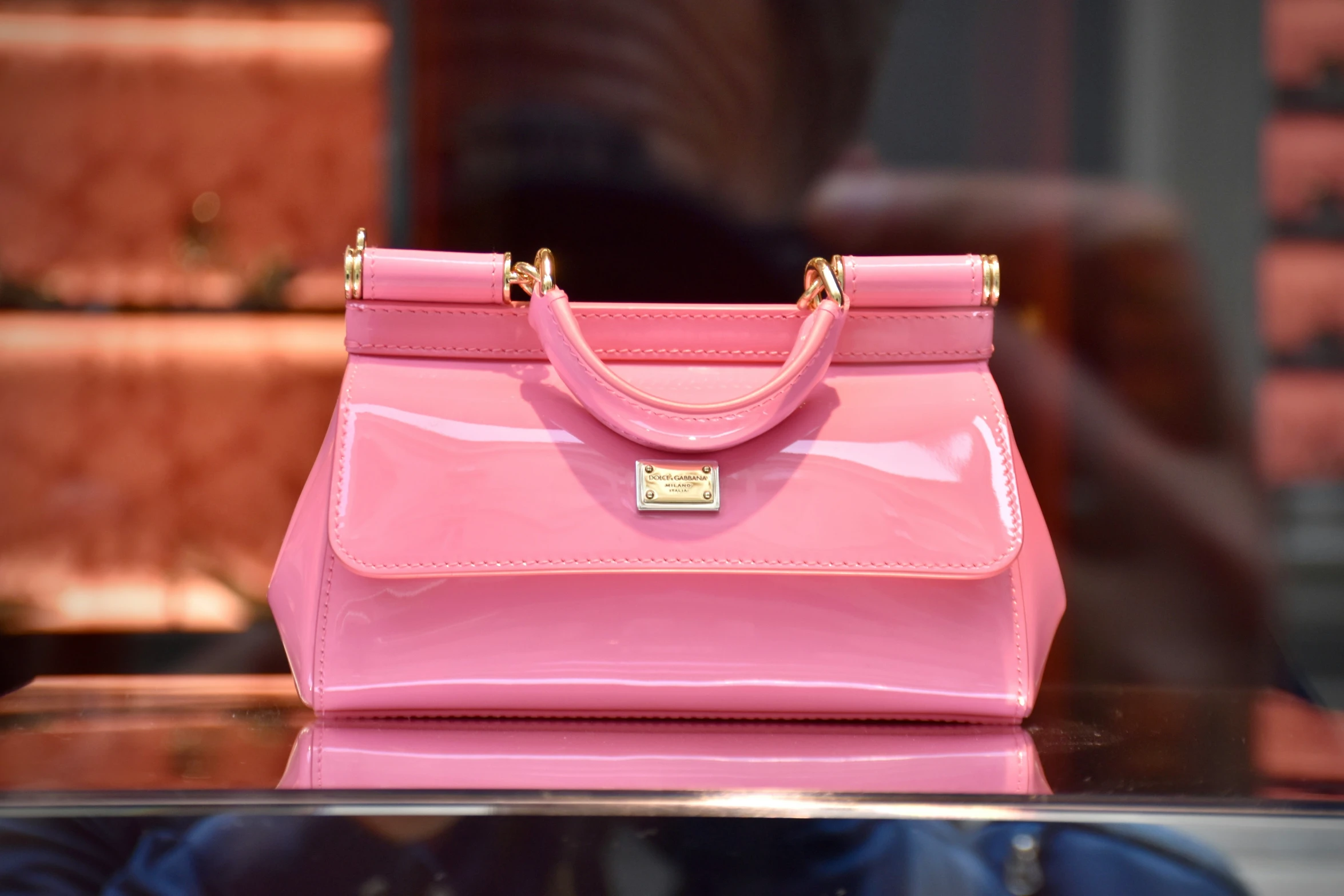 a pink purse sitting on top of a table next to a window