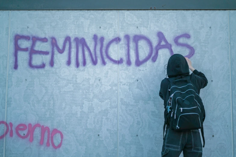 a person writing in graffiti on a wall