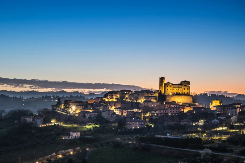 a castle like building at night on a hilltop