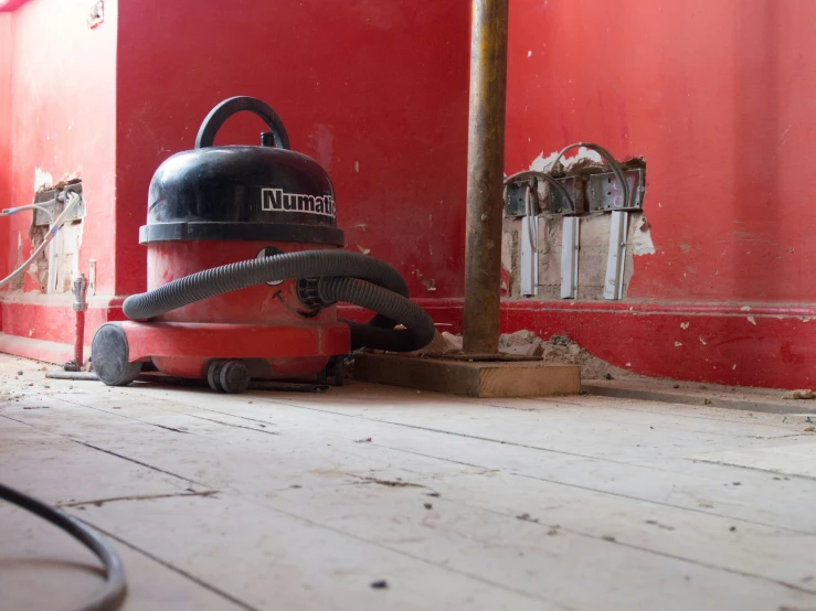 a black and red vacuum is laying on the floor