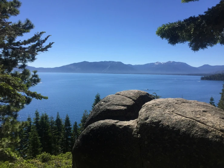 a picture taken from the top of a hill of an expansive lake