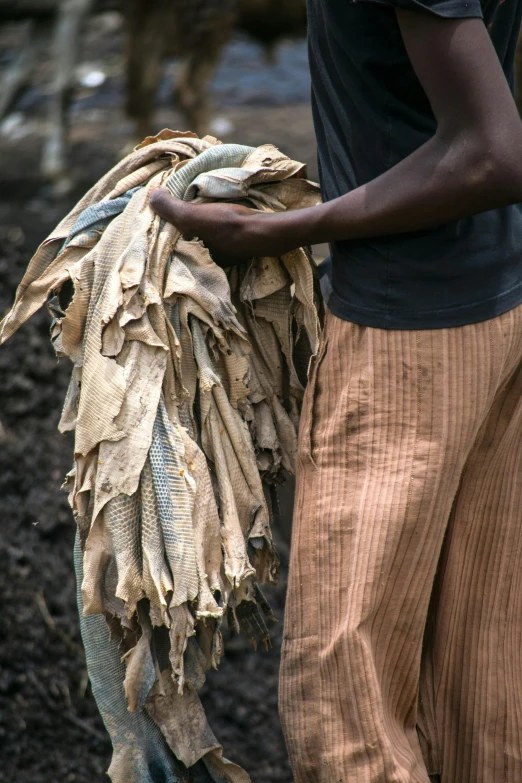 this man is holding a bundle of old things