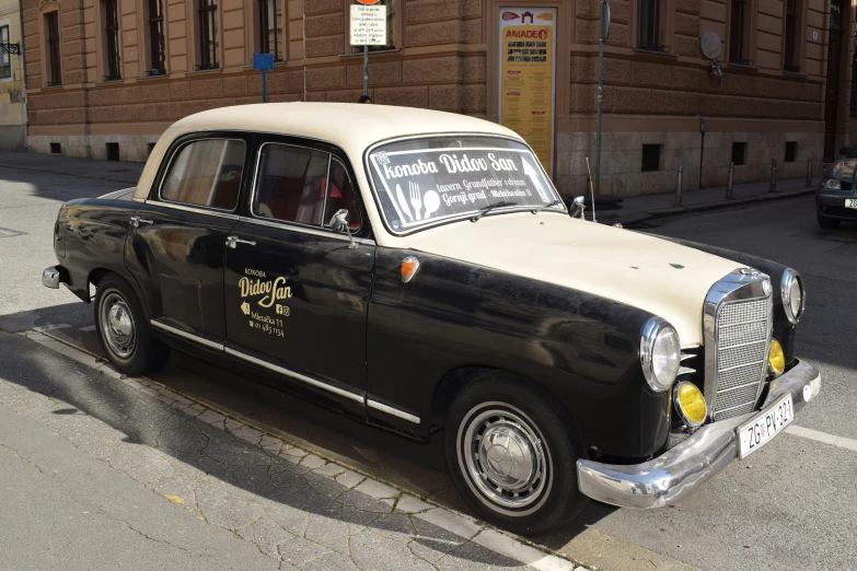 an old model black and white taxi on the street