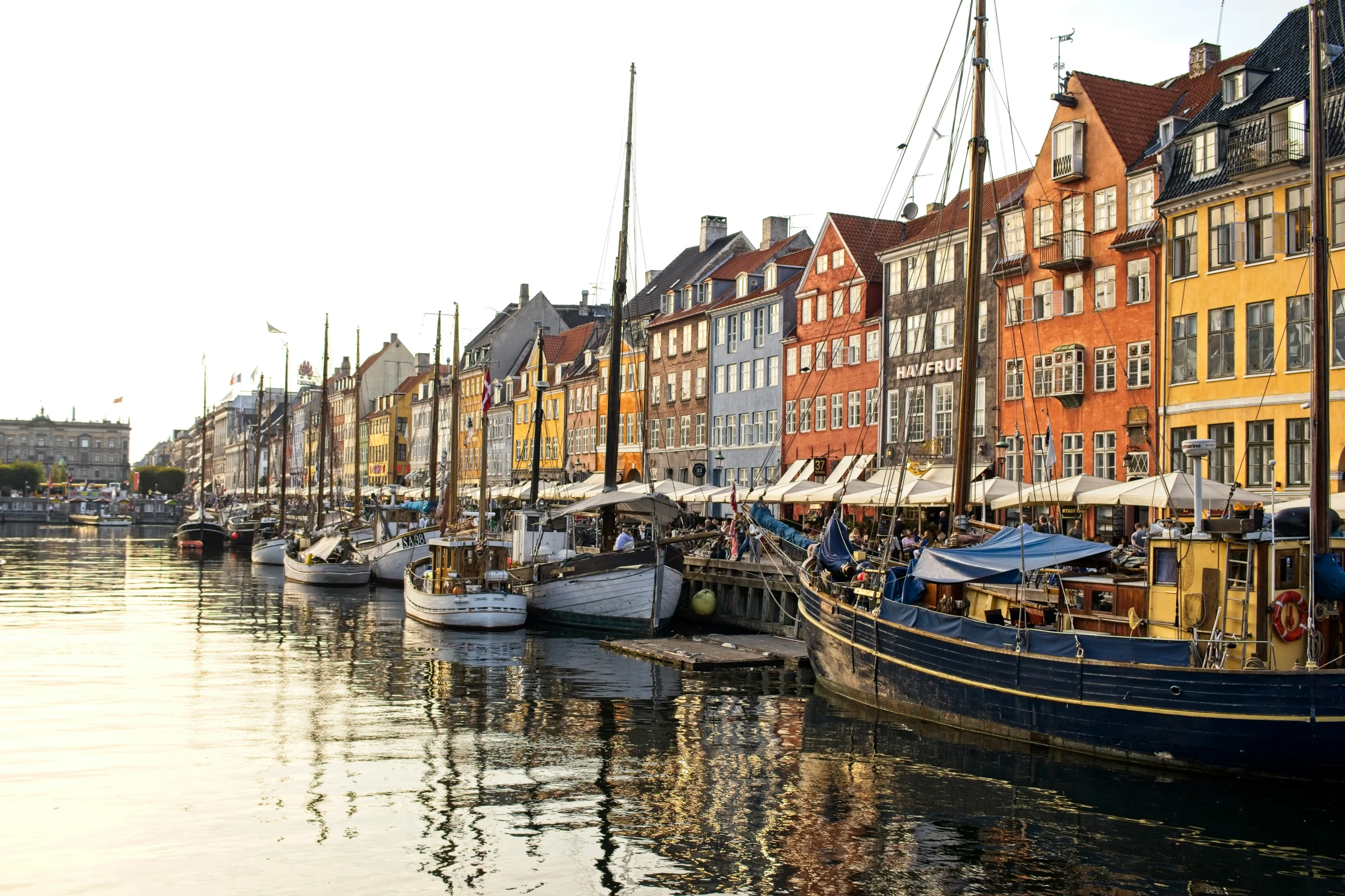 a body of water with many small boats parked near tall buildings