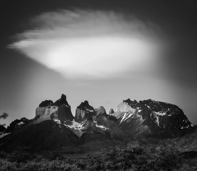 the view of a mountain with clouds coming in