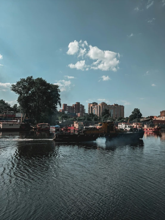 a river with boats in the background with buildings on both sides