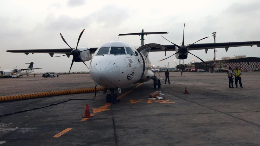 people are inspecting an airplane parked on the tarmac