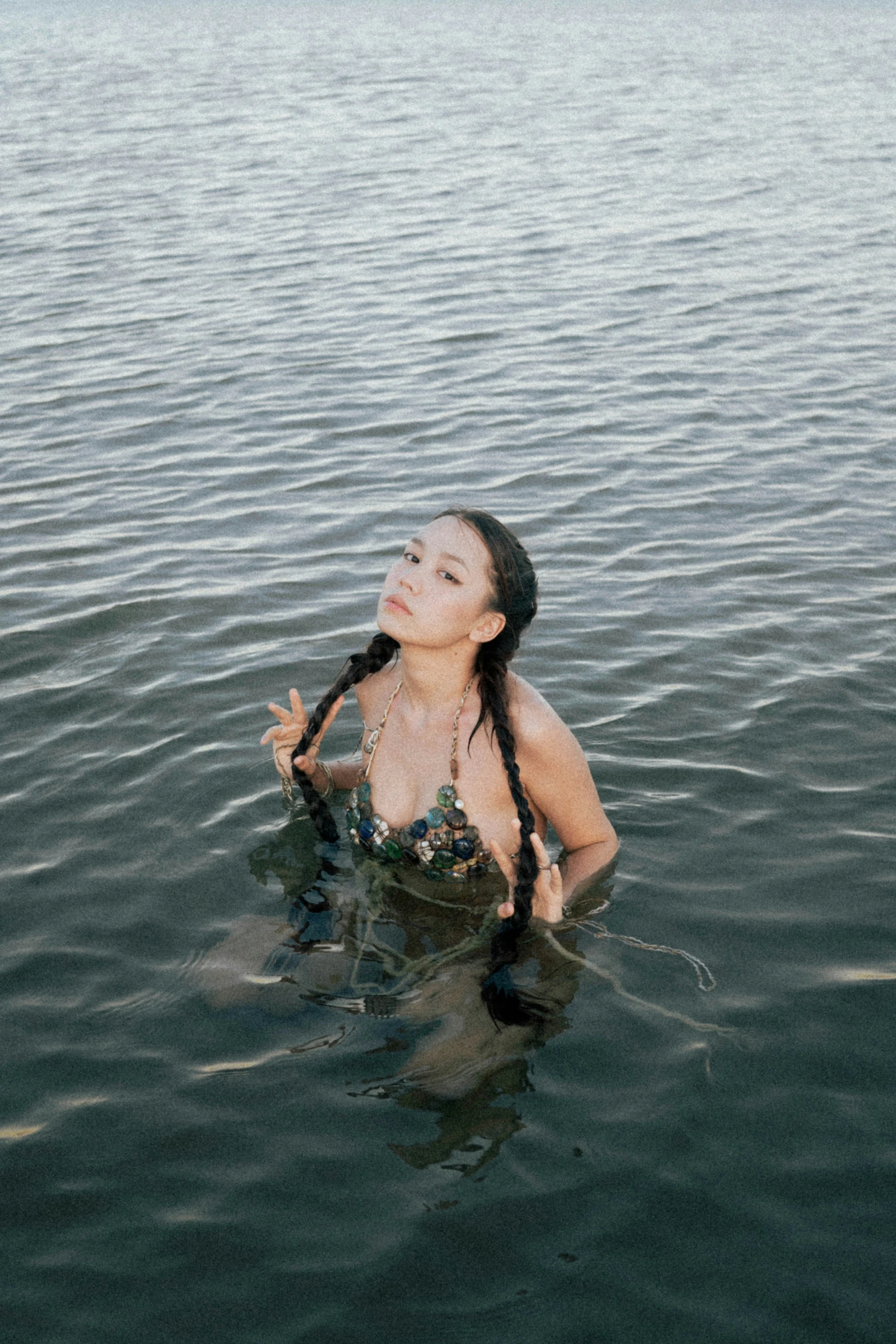 a woman wearing long hair sitting in water