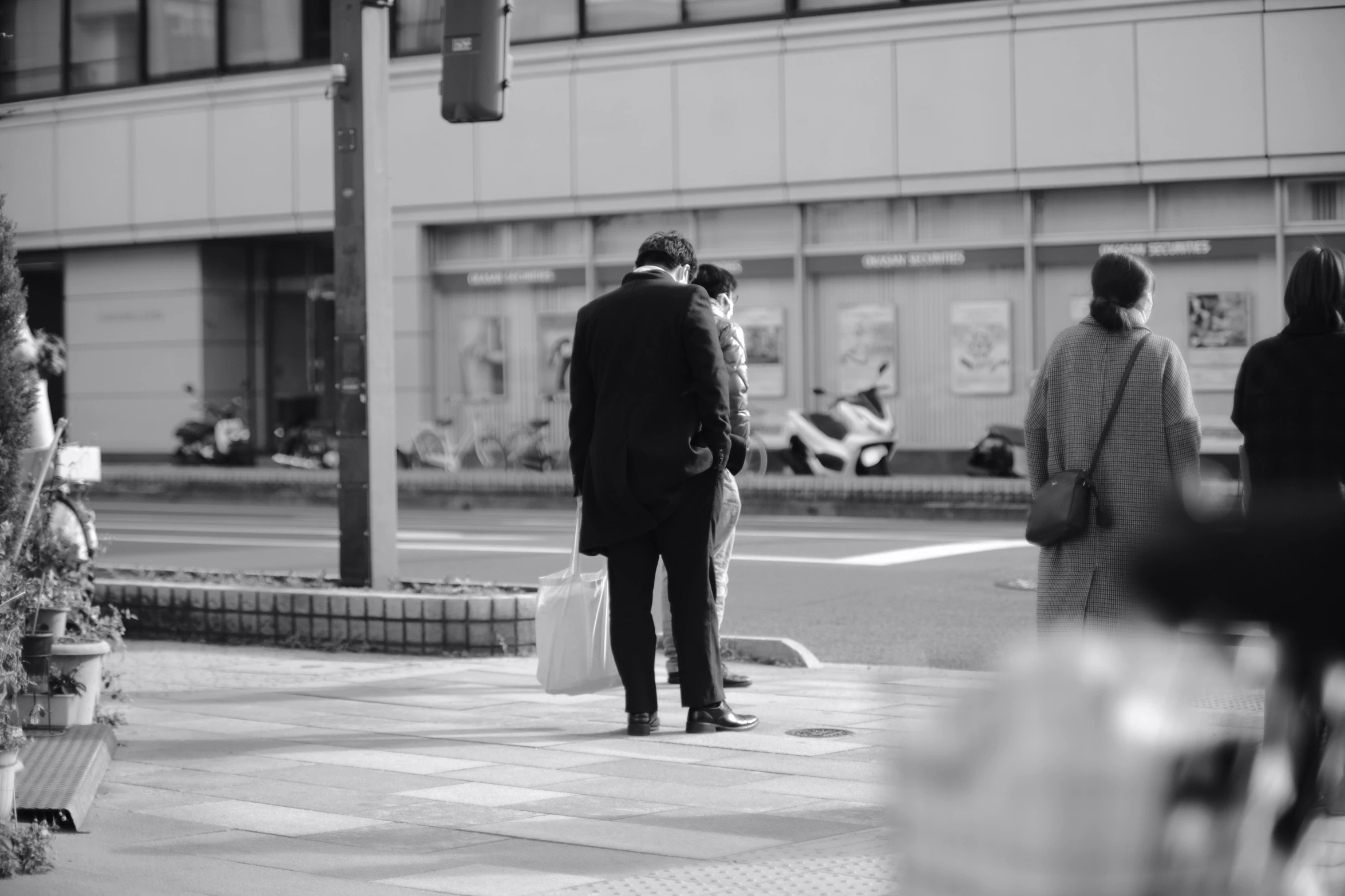 a group of people standing on a street corner near a crosswalk