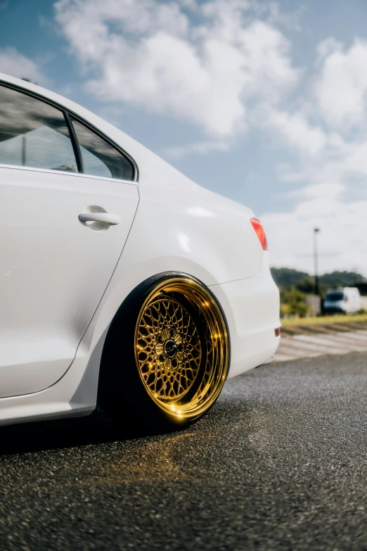 a car with gold rims and yellow tires is parked