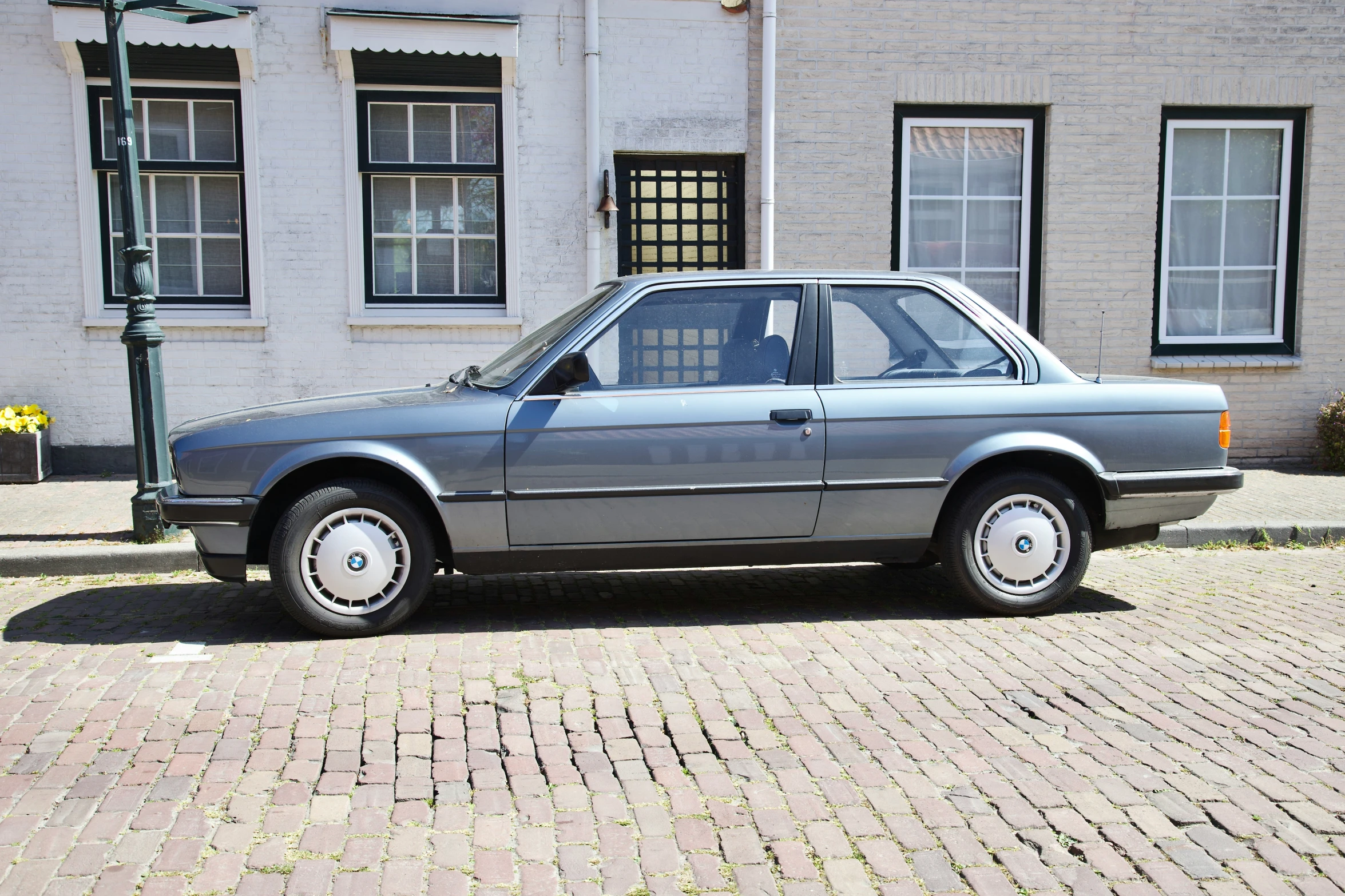 this is a silver car parked in front of a brick building