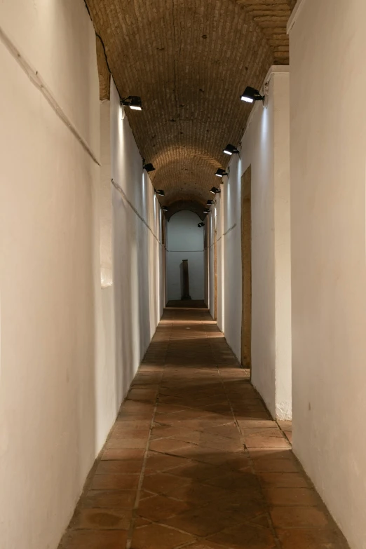 a long hallway with white walls and lights