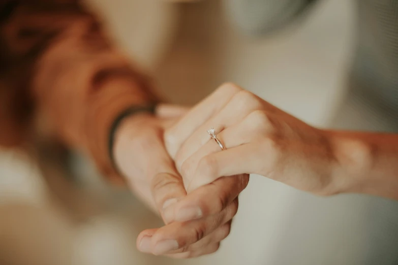 a close up of two people holding hands