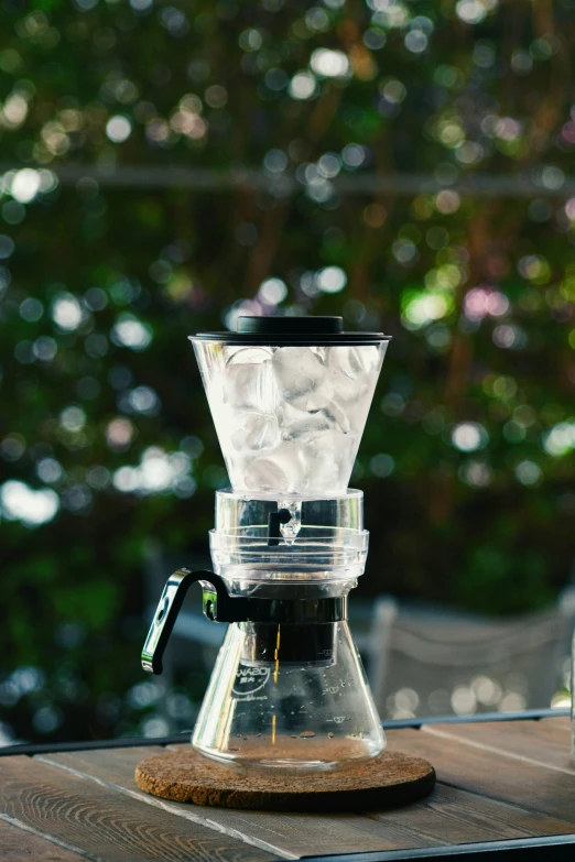 a small clear coffee maker on a wooden table