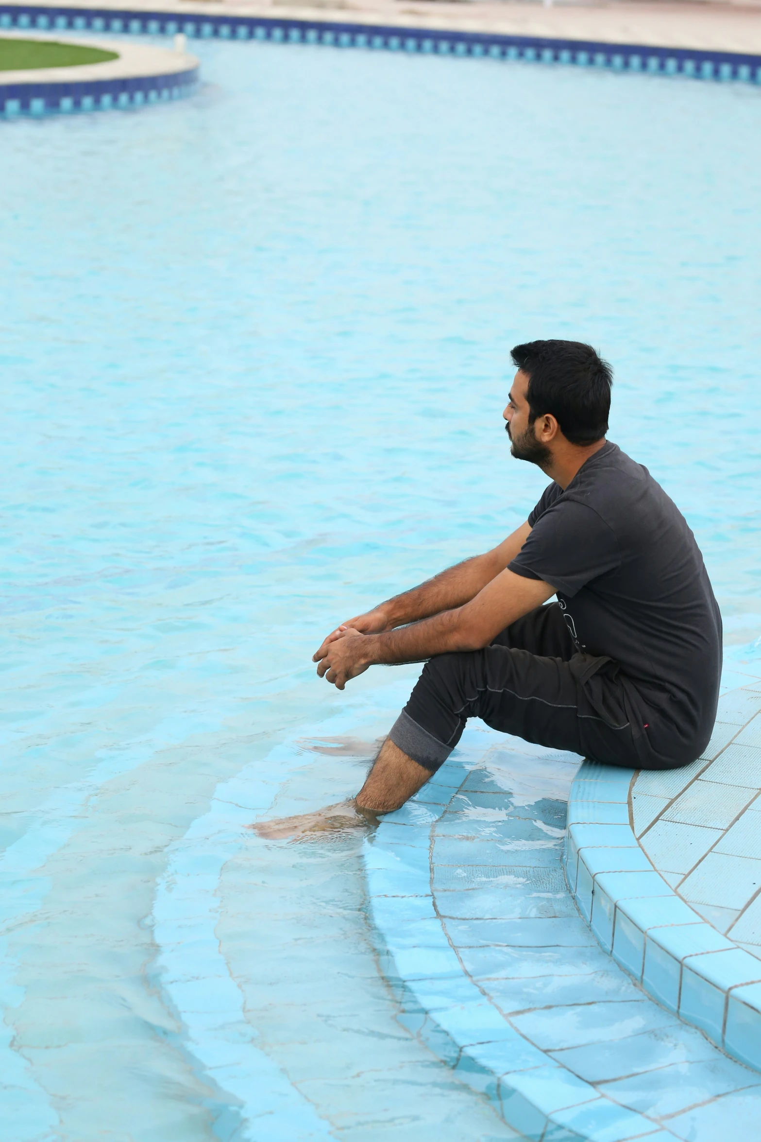 the man is sitting in the middle of the pool