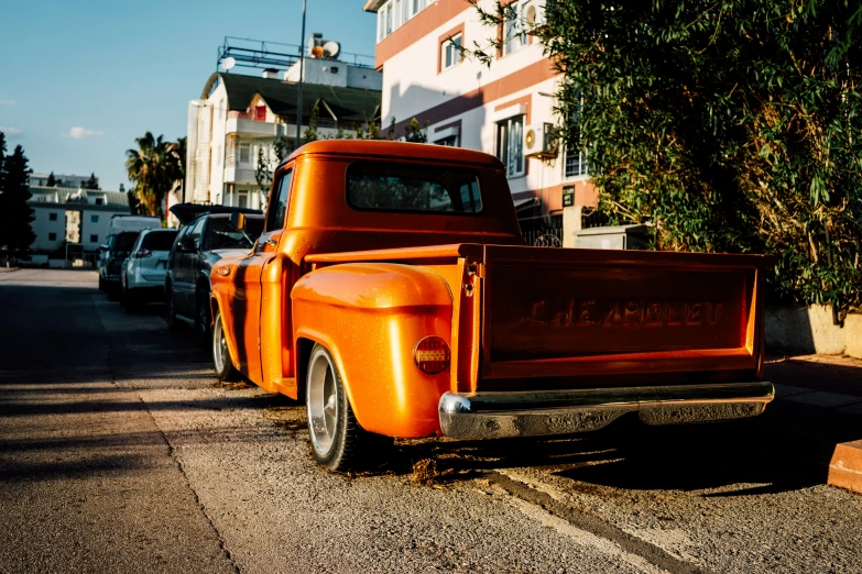 an orange truck parked along side of a building